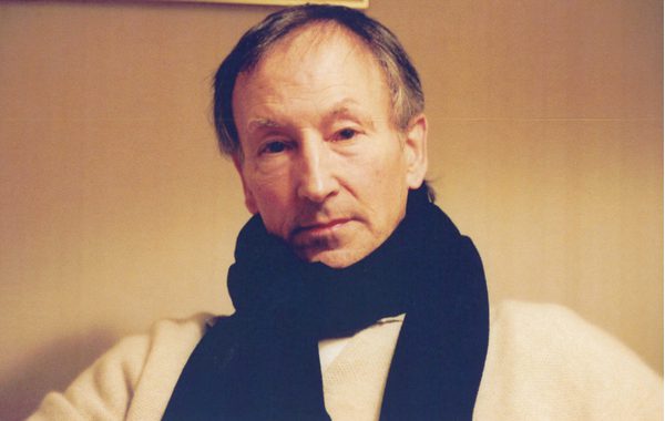 Portrait of David Morse, wearing a pale top and a dark scarf